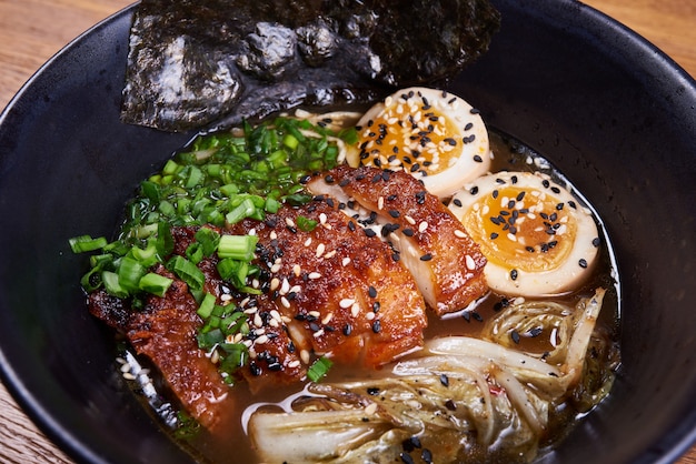 伝統的な日本のスープラーメン、麺、鶏肉のスライス、卵。閉じる。