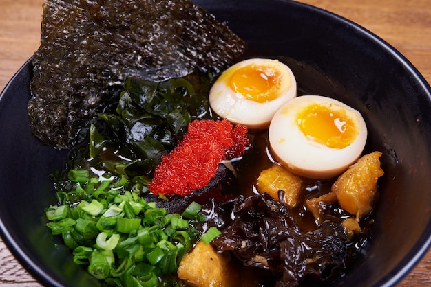 伝統的な日本のスープラーメン、麺、鶏肉のスライス、卵。閉じる。