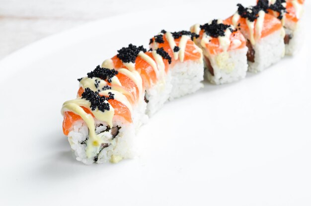 Traditional Japanese sushi rolls on a white plate Top view Asian food On a white background