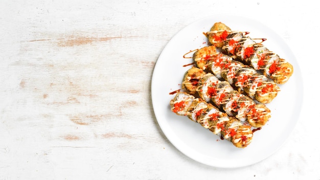 Traditional Japanese sushi rolls on a white plate Top view Asian food On a white background