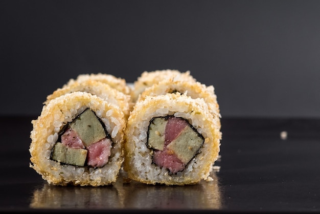 Traditional japenese cuisine Sushi rolls on black background