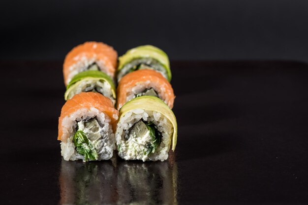 Traditional japenese cuisine Sushi rolls on black background