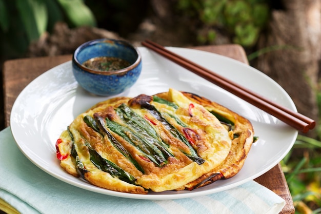 Photo traditional korean fritters with green onions and chili, served with soy sauce.