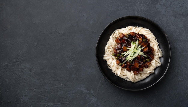 Traditional korean noodles in black bean sauce on a dark concrete background top view copy space