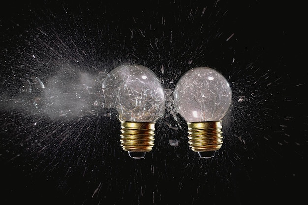 Traditional light bulbs with exploded glass on black.