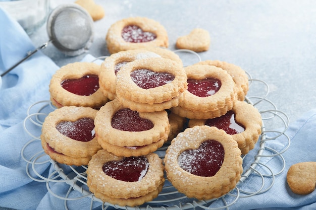 Traditional Linzer cookie with strawberry jam and powder sugar on light grey beautiful background Top view Traditional homemade Austrian sweet dessert food on Valentines Day Holiday snack concept