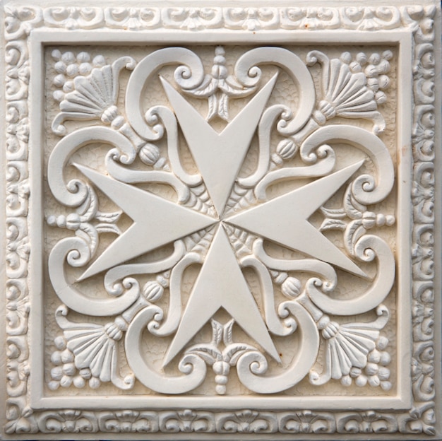 Traditional Maltese cross on the facade of old building in Mdina, Malta