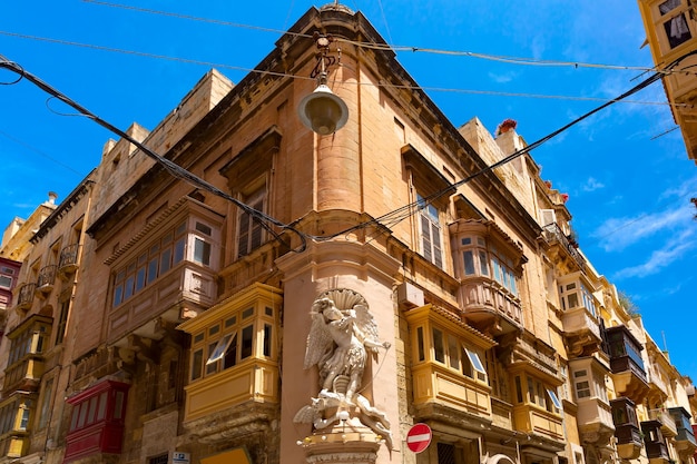 The traditional maltese street with corners of houses decorated with statues of saint in valletta ca