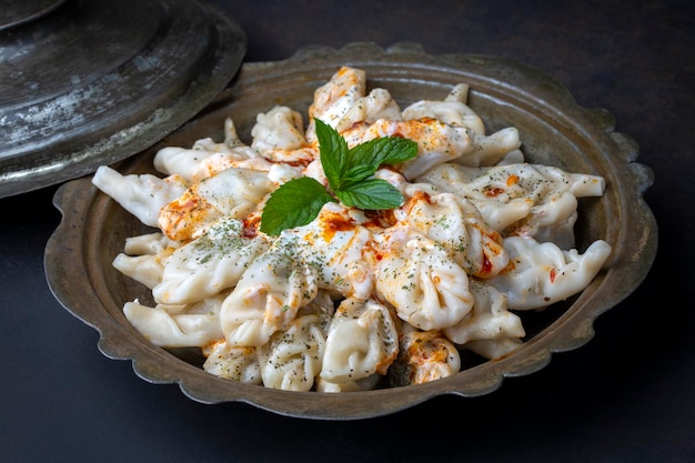 Traditional manti food on plate, top view. The concept of oriental cuisine. Uzbek food manty dumplings. (Turkish name; hinkel mantisi)