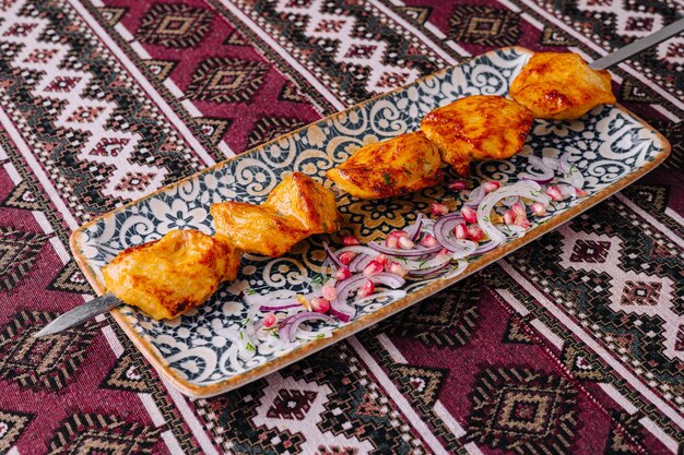 Foto tradizionali spicchi di pollo alla griglia marinati su piatto ornato