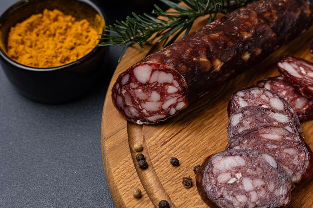 Traditional meat delicacies, sausages on a dark table