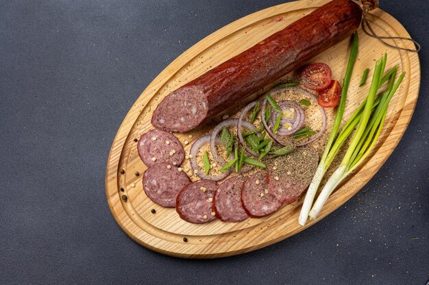 Traditional meat delicacies, sausages on a dark table