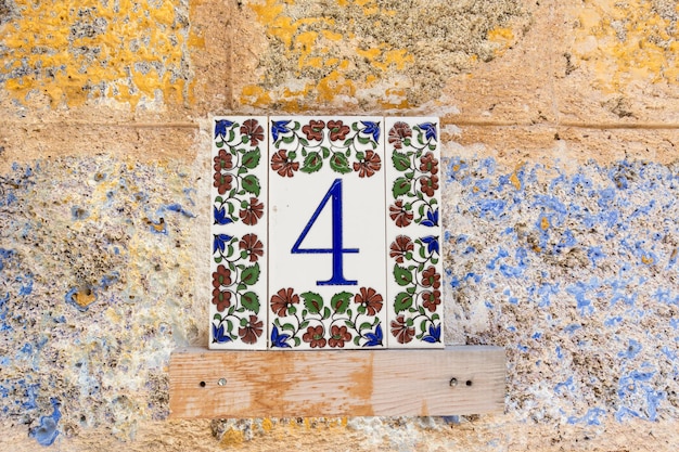 Traditional mediterranean greek pattern on a modern tile with\
digit 4 on it indicating a house number