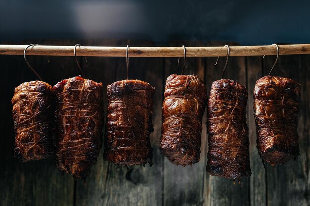 Traditional method of smoking meat in smoke smoked ham bacon\
pork neck and sausages in a smokehouse