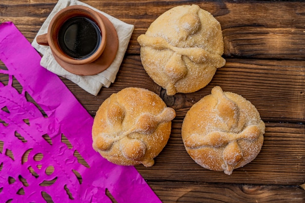 Traditional Mexican bread of the dead also known as Pan de Muerto on traditional Mexican table home