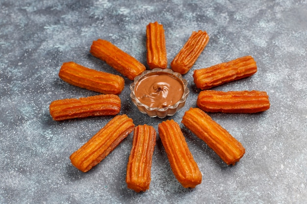 Traditional Mexican dessert churros with chocolate, top view