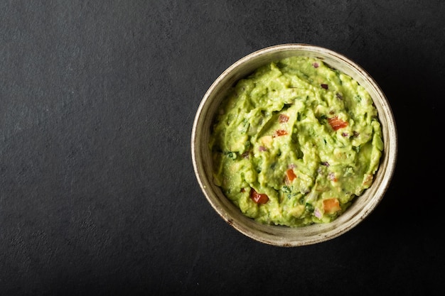 Traditional Mexican Guacamole sauce made from avocado lime red onion tomatoes cilantro