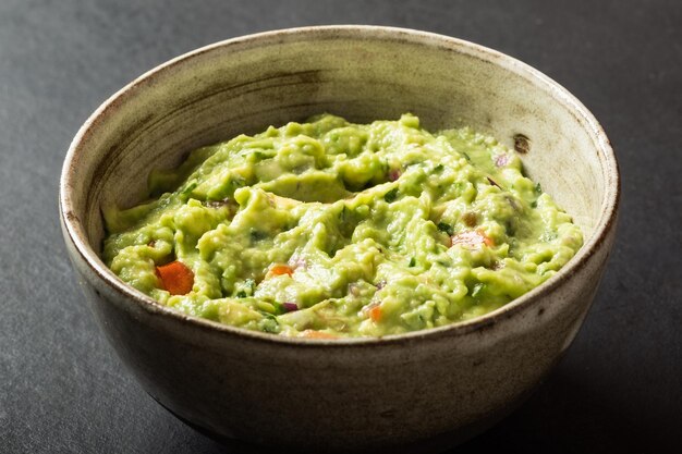 Traditional Mexican Guacamole sauce made from avocado lime red onion tomatoes cilantro