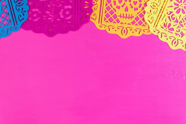 Traditional Mexican papel picado paper banner on a wood background.