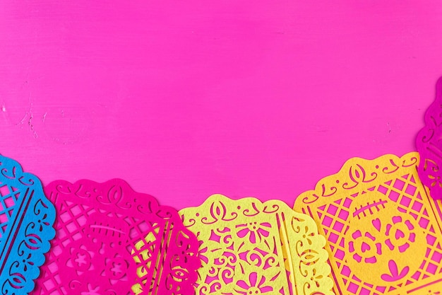 Traditional Mexican papel picado paper banner on a wood background.