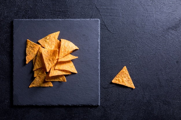 Nachos messicani tradizionali dello spuntino su un fondo nero