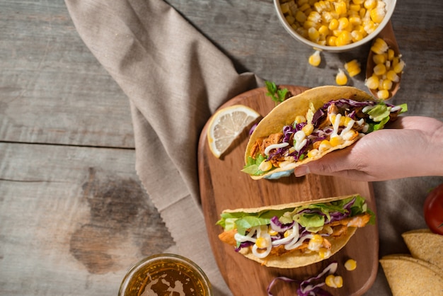 Traditional mexican taco with chicken and vegetables on wooden table. Latin american food.