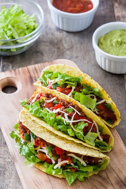 Traditional Mexican tacos with meat and vegetables on wood