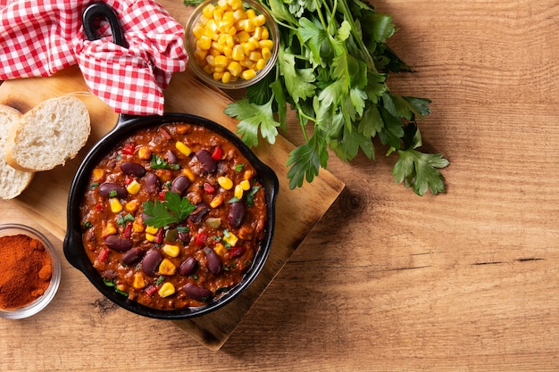 Foto tradizionale messicano tex mex chili con carne in padella di ferro su tavola di legno