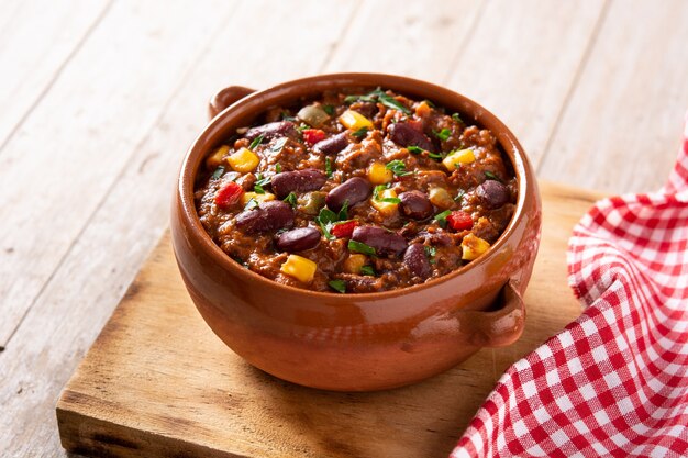 Traditional mexican tex mex chili con carne on wooden table.