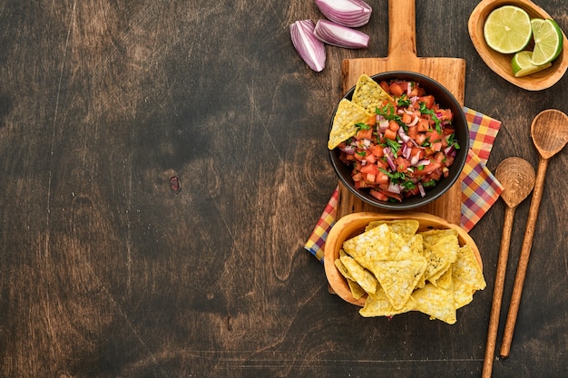 traditional mexican tomato sauce salsa with nachos and ingredients tomatoes, chile, garlic, onion 