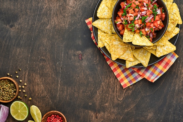 Salsa di pomodoro tradizionale messicana salsa con nachos e ingredienti pomodori, peperoncino, aglio, cipolla