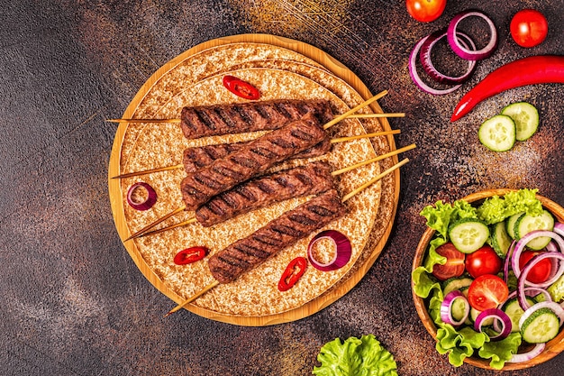 Traditional middle eastern arabic or mediterranean meat kebab with vegetables and lavash bread