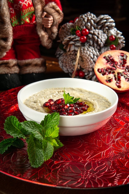 写真 伝統的な中東料理。レバノン料理。ザクロの種とクリスマスの装飾が施されたアラビアのババガヌーシュ