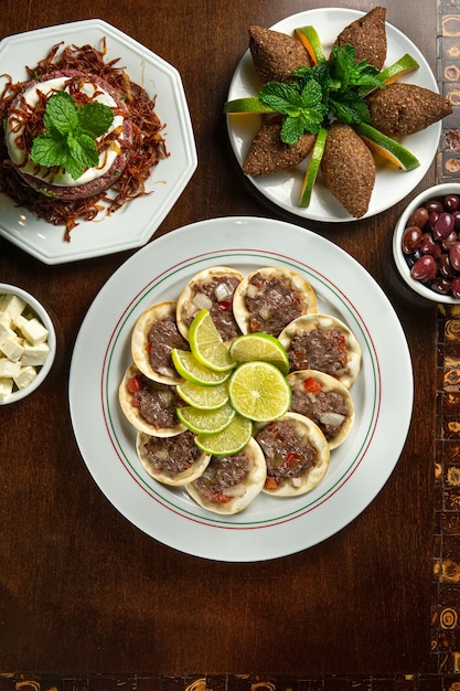 Фото Традиционная ближневосточная кухня. ливанское мясо сфихи. арабская тарелка сфиха. эсфиха с лимонами. kibbeh kibe. вид сверху