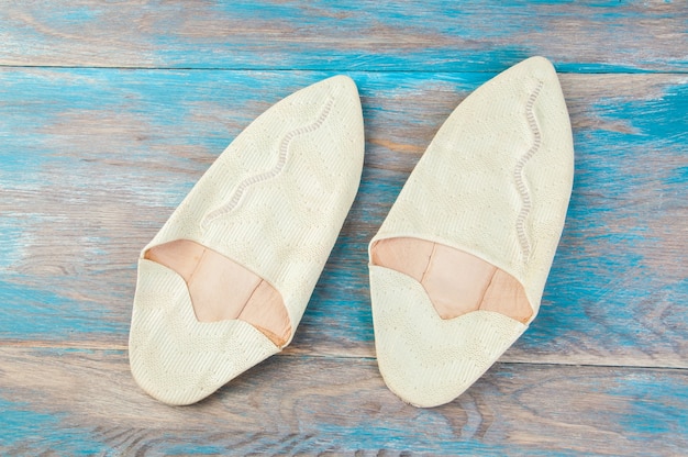 Traditional moroccan shoes on blue wooden background. 
