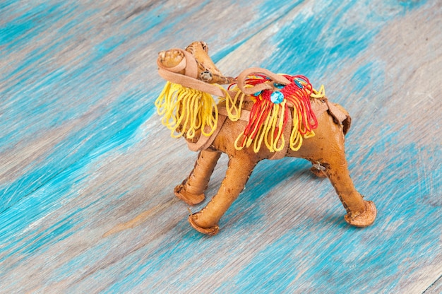 Traditional moroccan souvenir, leather camel on blue wooden\
background.