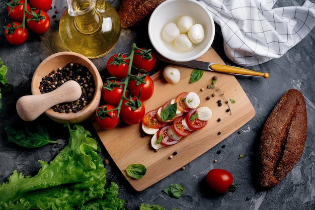 Foto mozzarella tradizionale con pomodori ed erbe aromatiche.