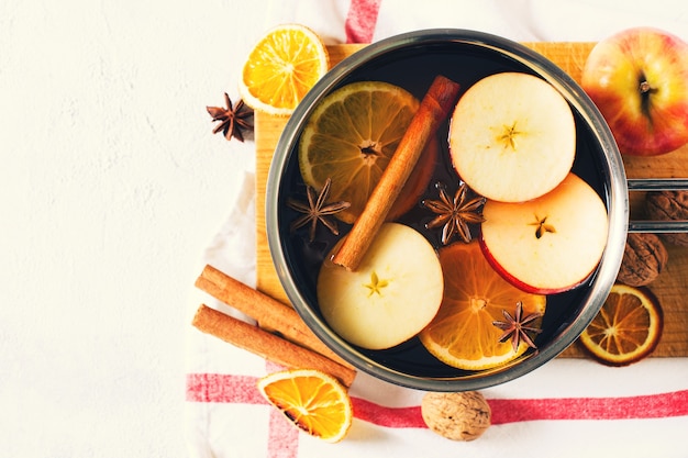 Traditional mulled wine in pot with spice on white