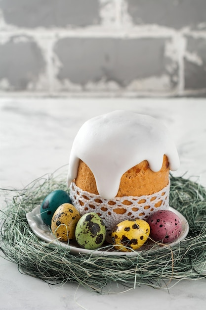 Traditional Orthodox Easter bread Kulich with colorful quail eggs on a light