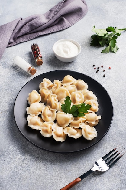 Traditional pelmeni ravioli dumplings filled with meat on plate russian kitchen Light concrete background copy space