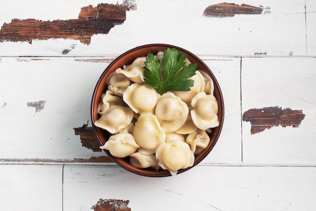 Ravioli tradizionali pelmeni gnocchi ripieni di carne su piastra cucina russa rustico in legno sfondo spazio copia