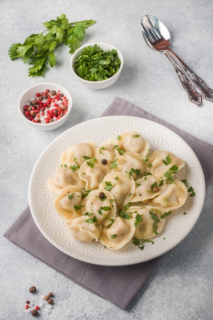 Традиционные пельмени, пельмени, вареники с мясом на тарелке, русская кухня.