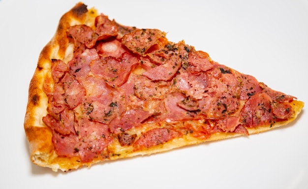 Traditional pepperoni pizza slice in selective focus.