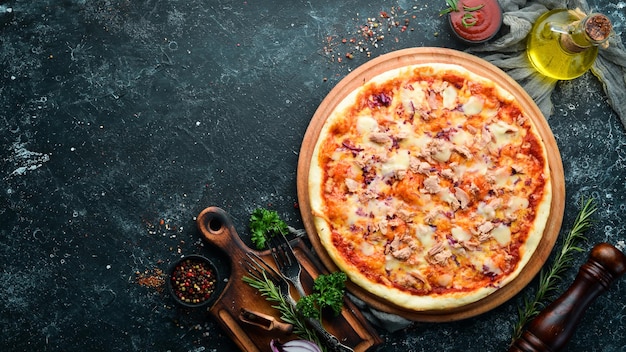 Traditional pizza with tuna and vegetables. Top view. free space for your text. Rustic style.