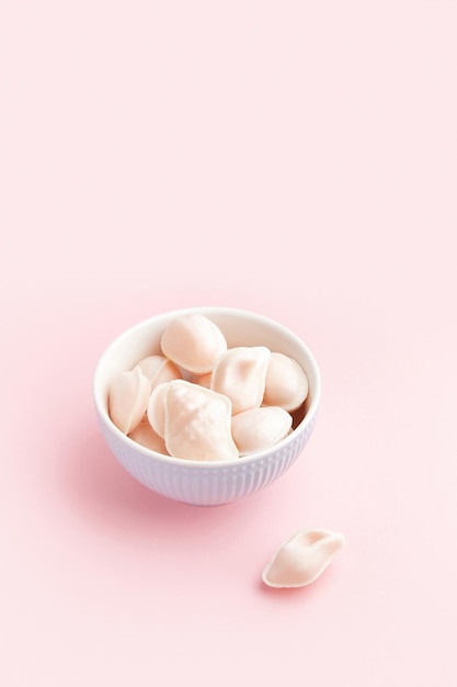 Traditional portuguese egg yolk sweets ovos moles de aveiro on pink background confectionery shop