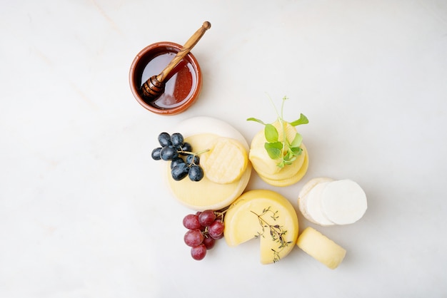 Traditional Portuguese semi-soft cheeses served with fresh grapes, honey and herbs. Top view