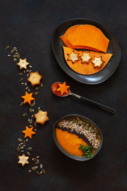 Traditional pumpkin homemade cream-soup with seeds, crackers and pumpkin slices.