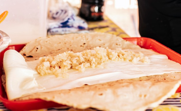 玉ねぎのピクルスを添えた伝統的なケシージョ 伝統的なニカラグアのケシージョの準備 おいしいニカラグアのチーズを作る人 伝統的なニカラグアのケシージョを準備する手
