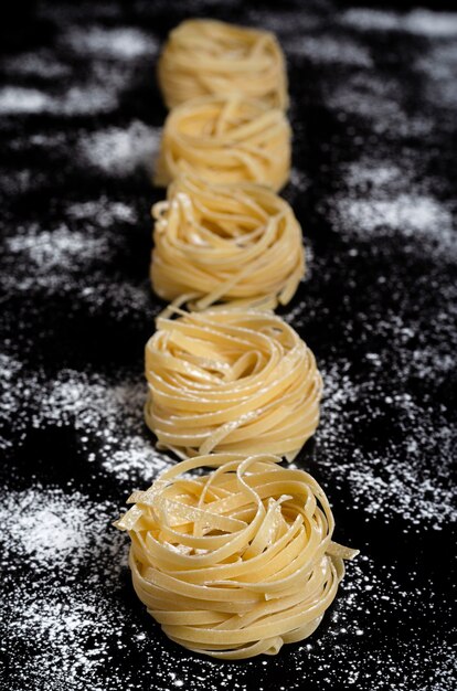 Traditional raw dry italian uncooked fettuccine, fettuccine or tagliatelle.