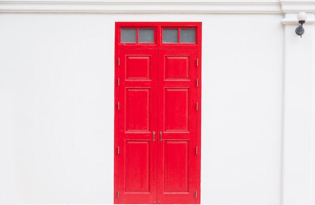 Photo traditional red door wooden of an old on white wall, in thailand